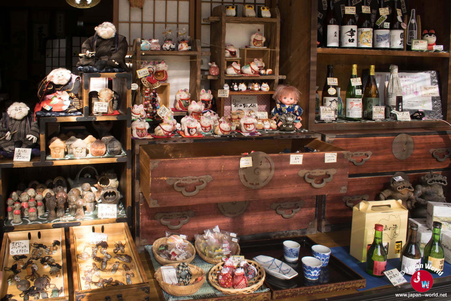 Artisanat d’Aizu, poupées et bouteilles de saké exposés dans une boutique d’Ōuchi-juku